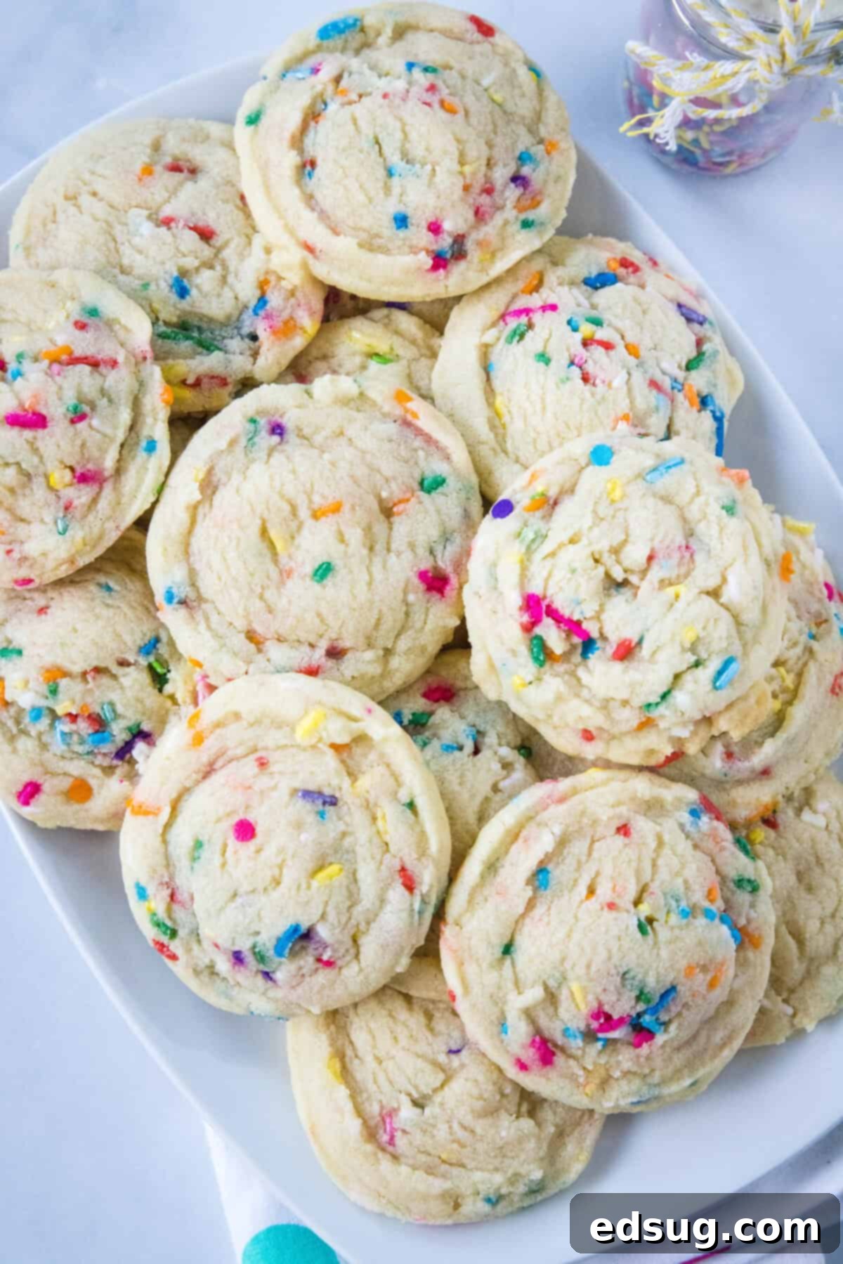 Looking down on a stack of colourful Funfetti cookies on a white plate