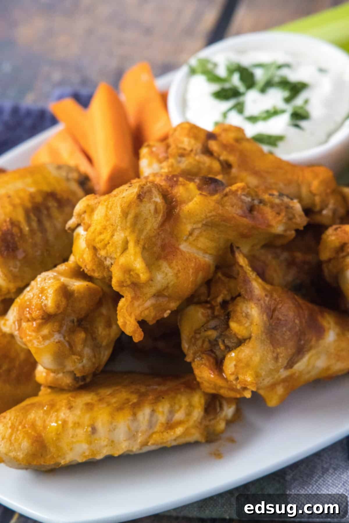 Fall-Off-The-Bone Crockpot Wings 2 buffalo chicken wings on a plate, perfectly cooked