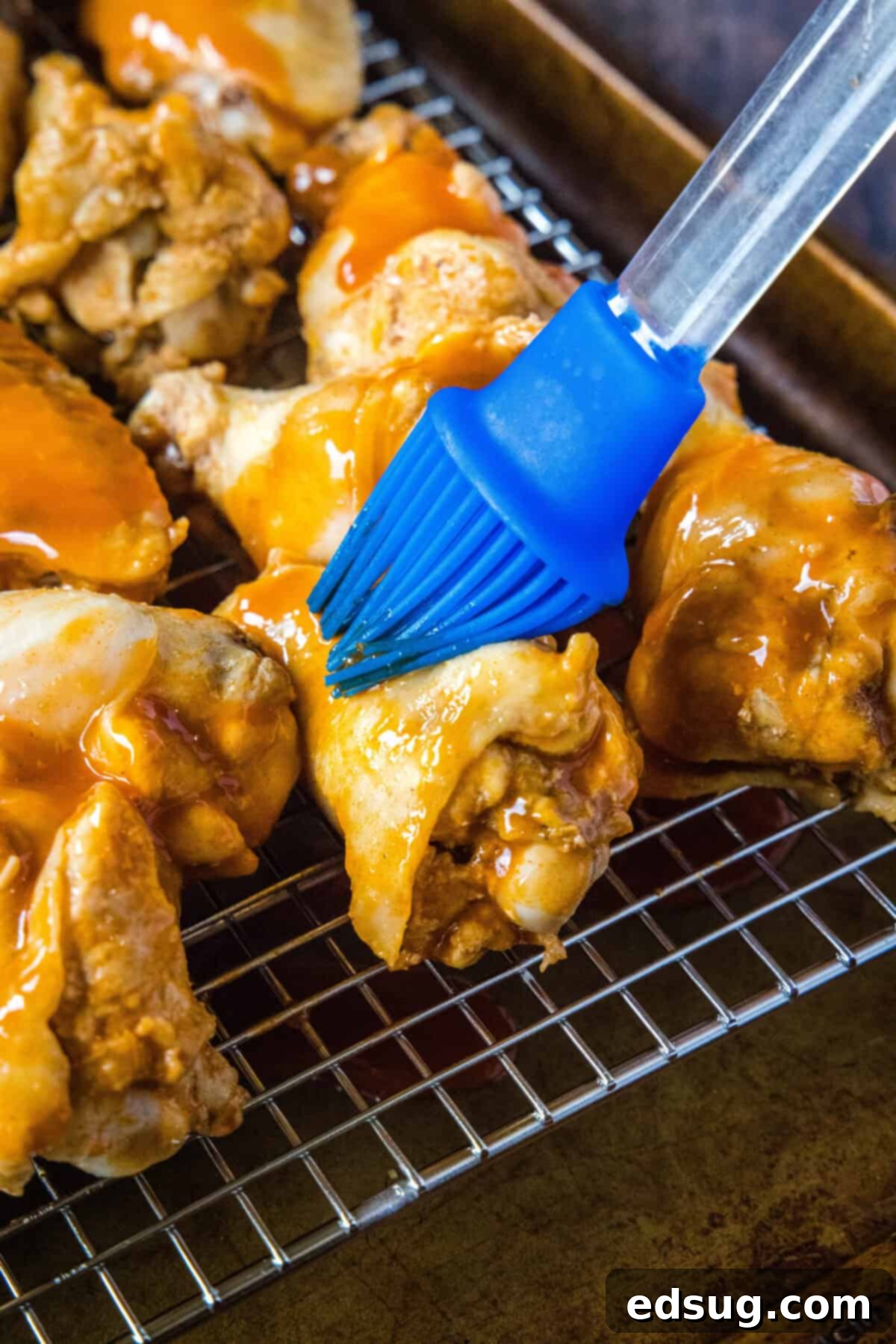 Fall-Off-The-Bone Crockpot Wings 4 brushing sauce on chicken wings before broiling