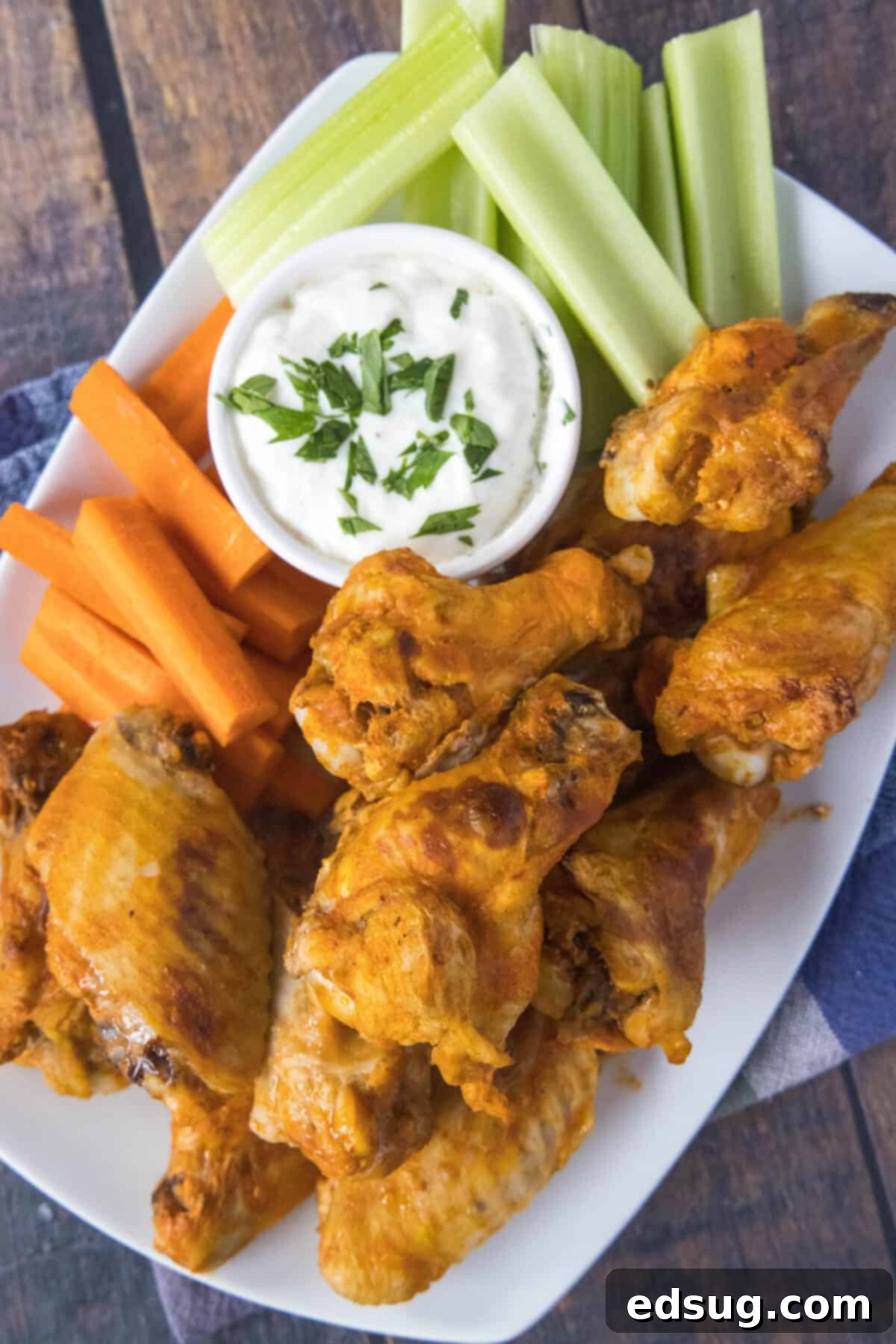 Fall-Off-The-Bone Crockpot Wings 5 looking down on a plate of chicken wings with carrots and celery