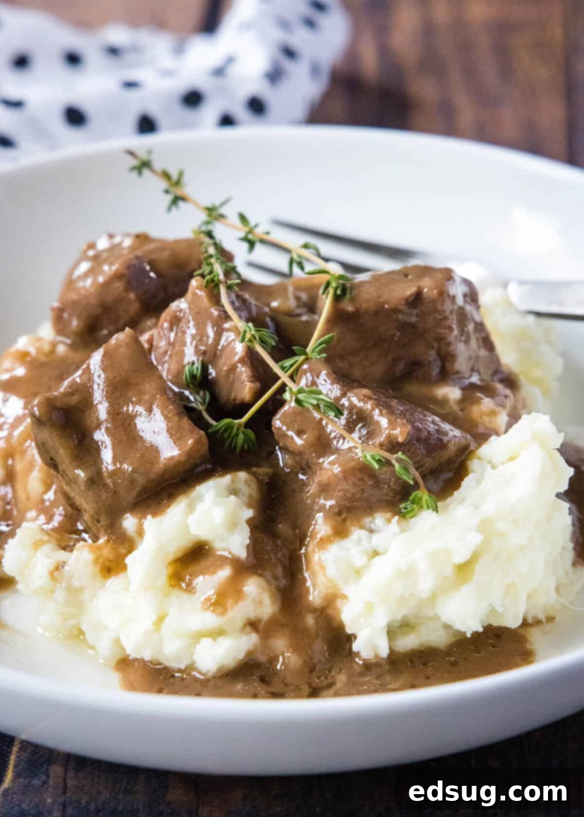Tender No Peek Beef Tips in rich gravy served over creamy mashed potatoes, a perfect comfort meal.