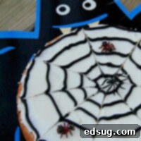 A large chocolate chip cookie decorated with a spooky spider web design