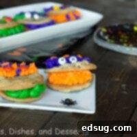 Monster cookies on a plate with colorful frosting and candy eyes