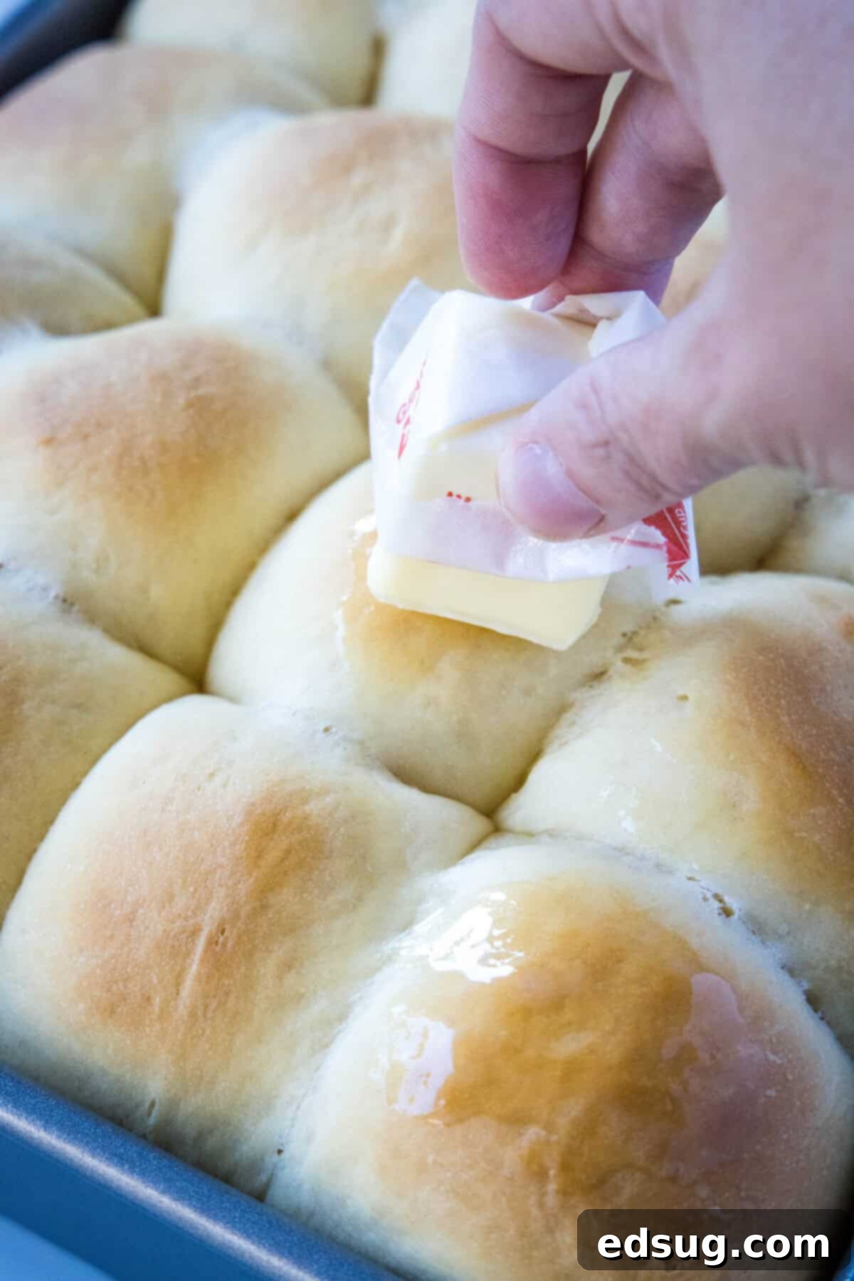 spreading butter on baked rolls