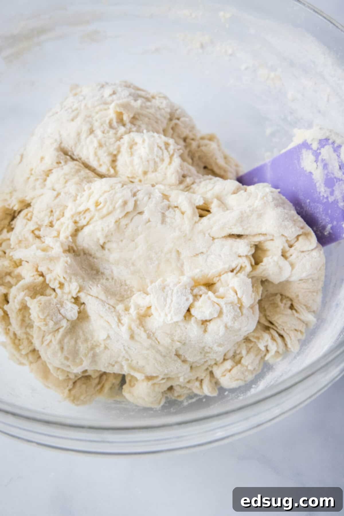 Effortless Slow Cooker Bread 5 Shaggy bread dough forming in a large mixing bowl after initial ingredients have been combined, prior to kneading.