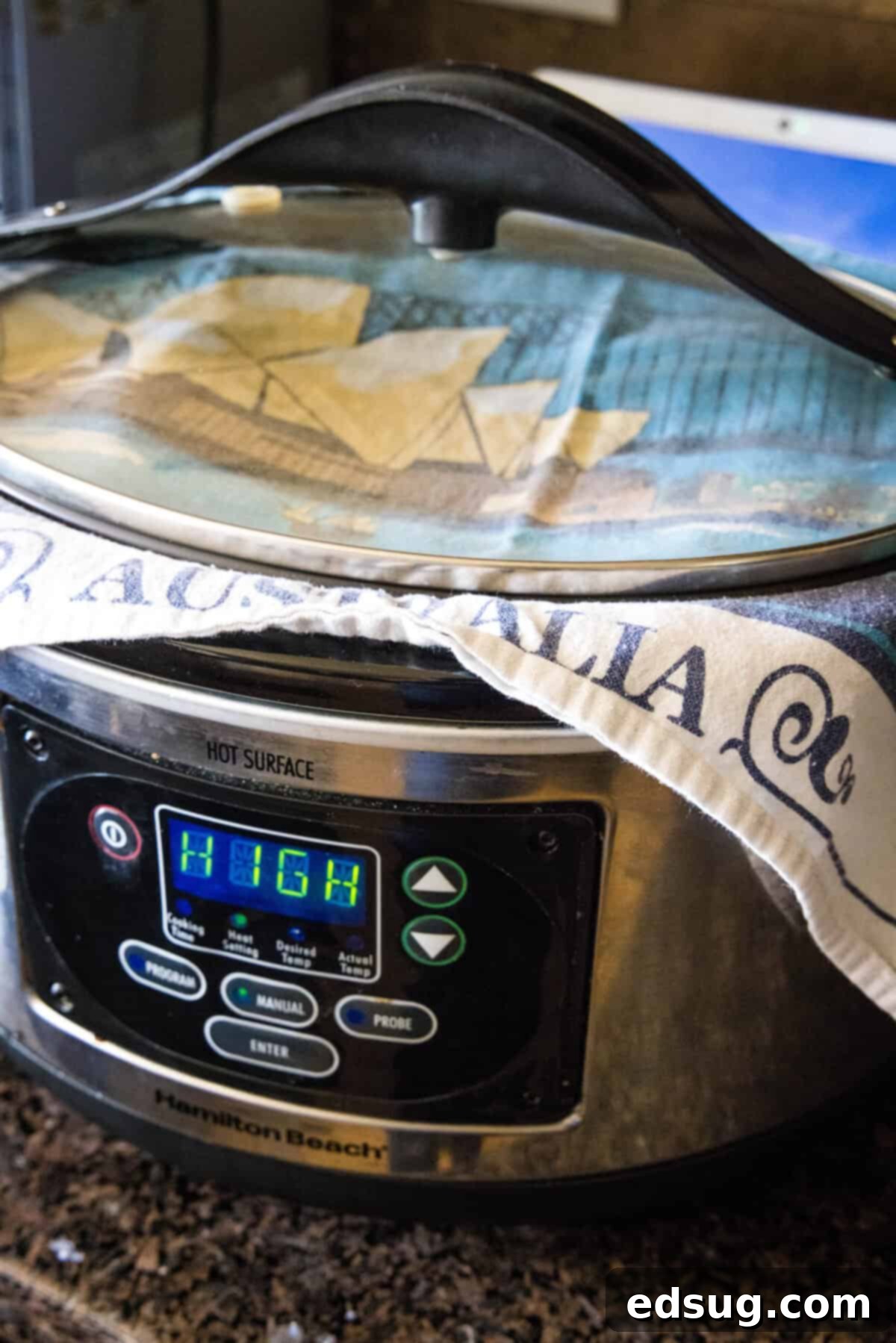 Effortless Slow Cooker Bread 6 A tea towel placed over the top of a slow cooker before the lid is put on, demonstrating a key step for slow cooker bread preparation to prevent condensation.