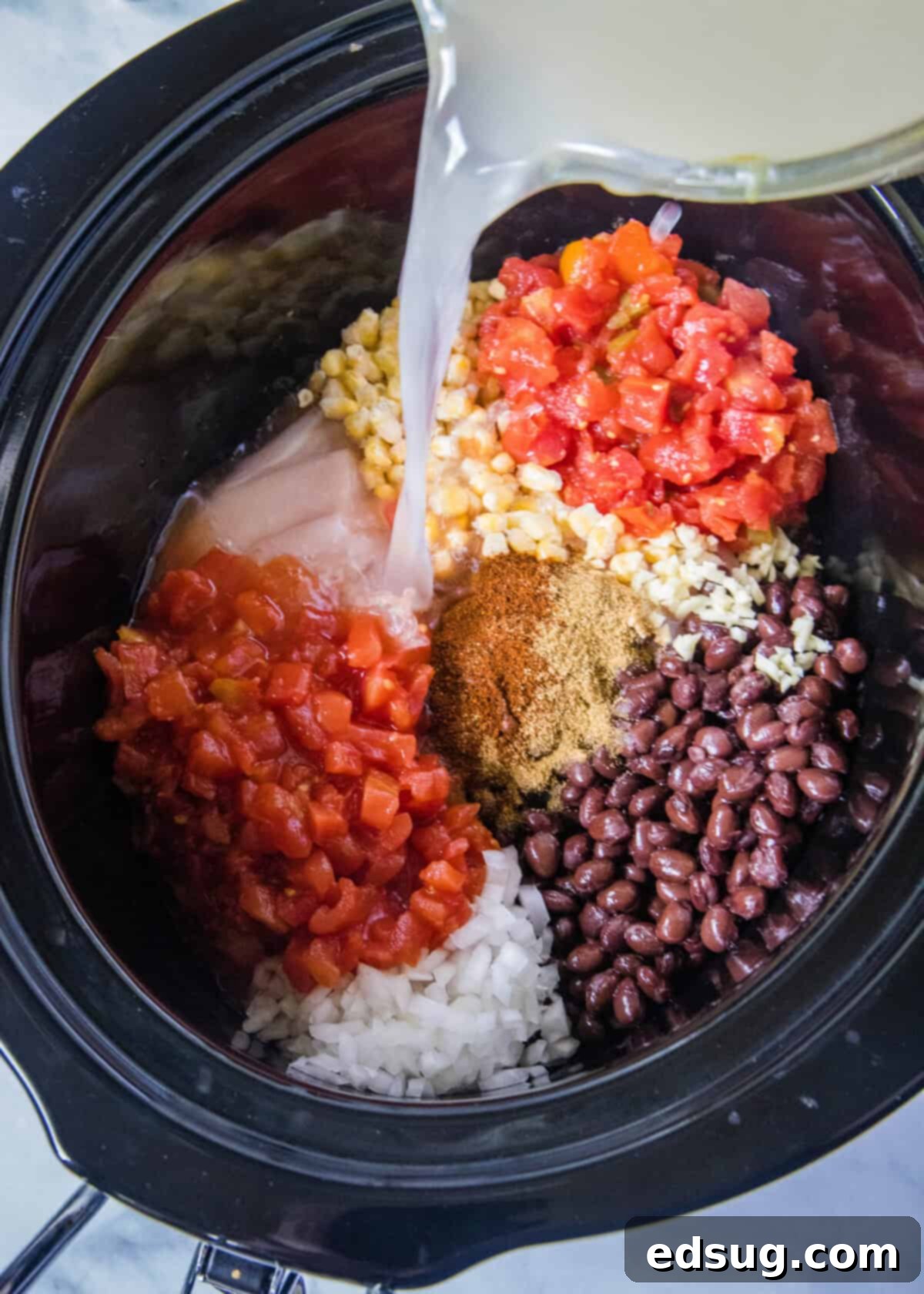 All the fresh ingredients for Crockpot Chicken Tortilla Soup in a slow cooker, ready to be cooked.