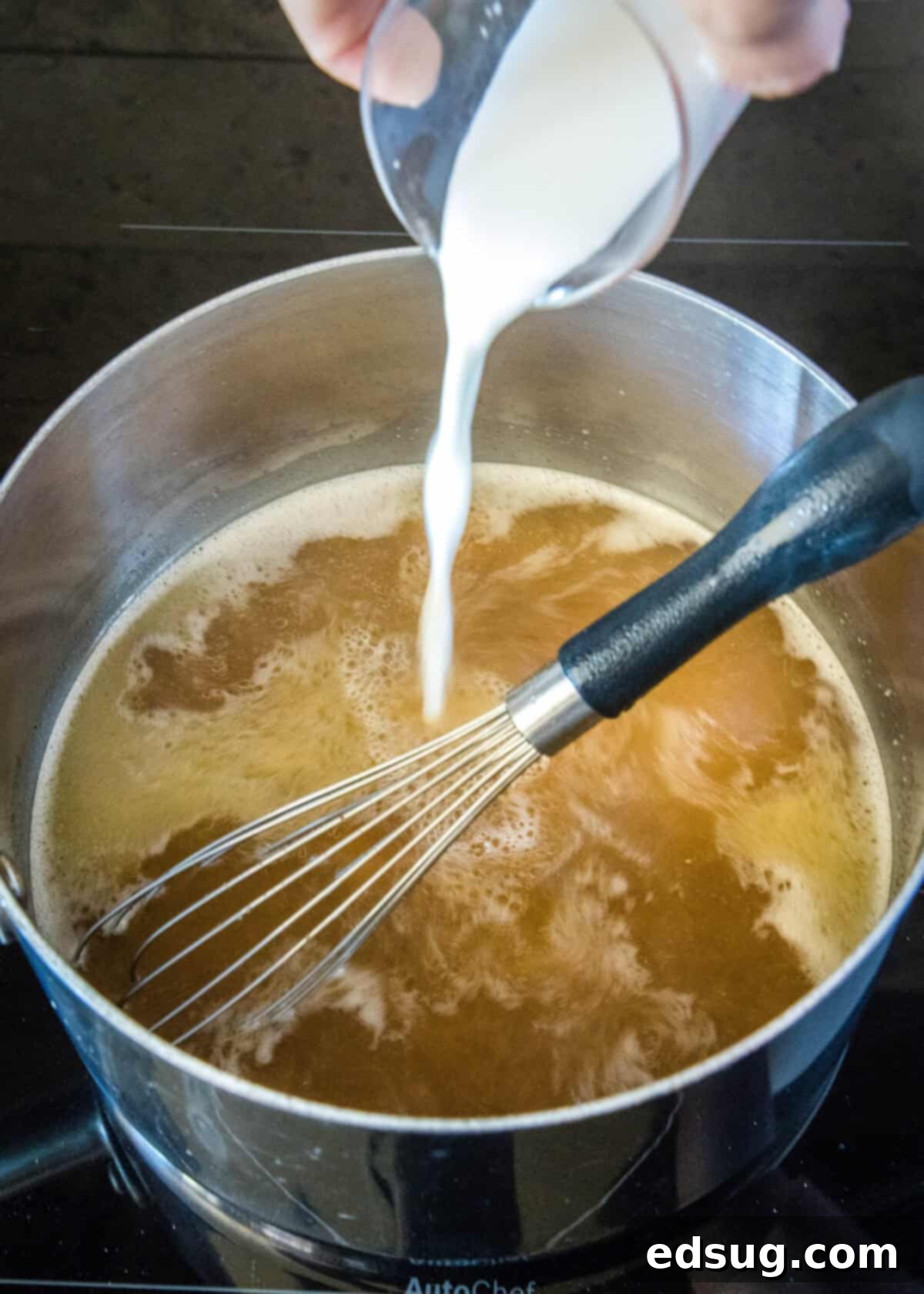 Hearty Pan Gravy 5 pouring slurry into broth mixture in a saucepan