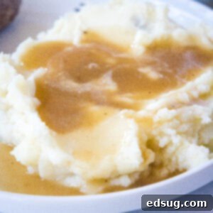 Hearty Pan Gravy 9 close up of brown gravy over mashed potatoes on a white plate
