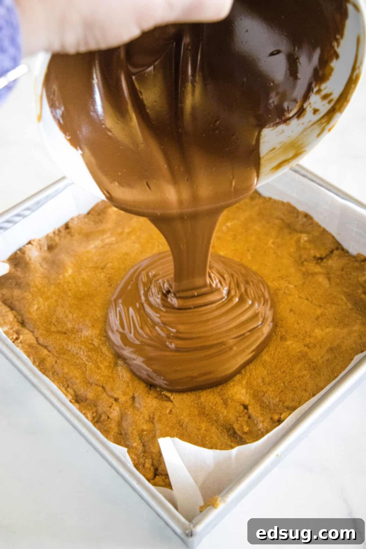 pouring melted chocolate over biscoff bars