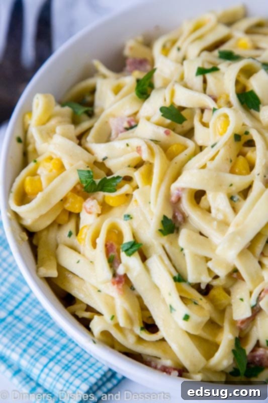 Fiesta Carbonara 4 A close-up shot of a ceramic bowl brimming with creamy pasta carbonara with corn and chilies, highlighting the texture and rich sauce