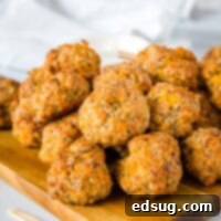 Cheesy Sausage Meatballs - A classic comfort food appetizer that is perfect for your holiday party! So easy to make, ready in minutes, and they disappear every time.