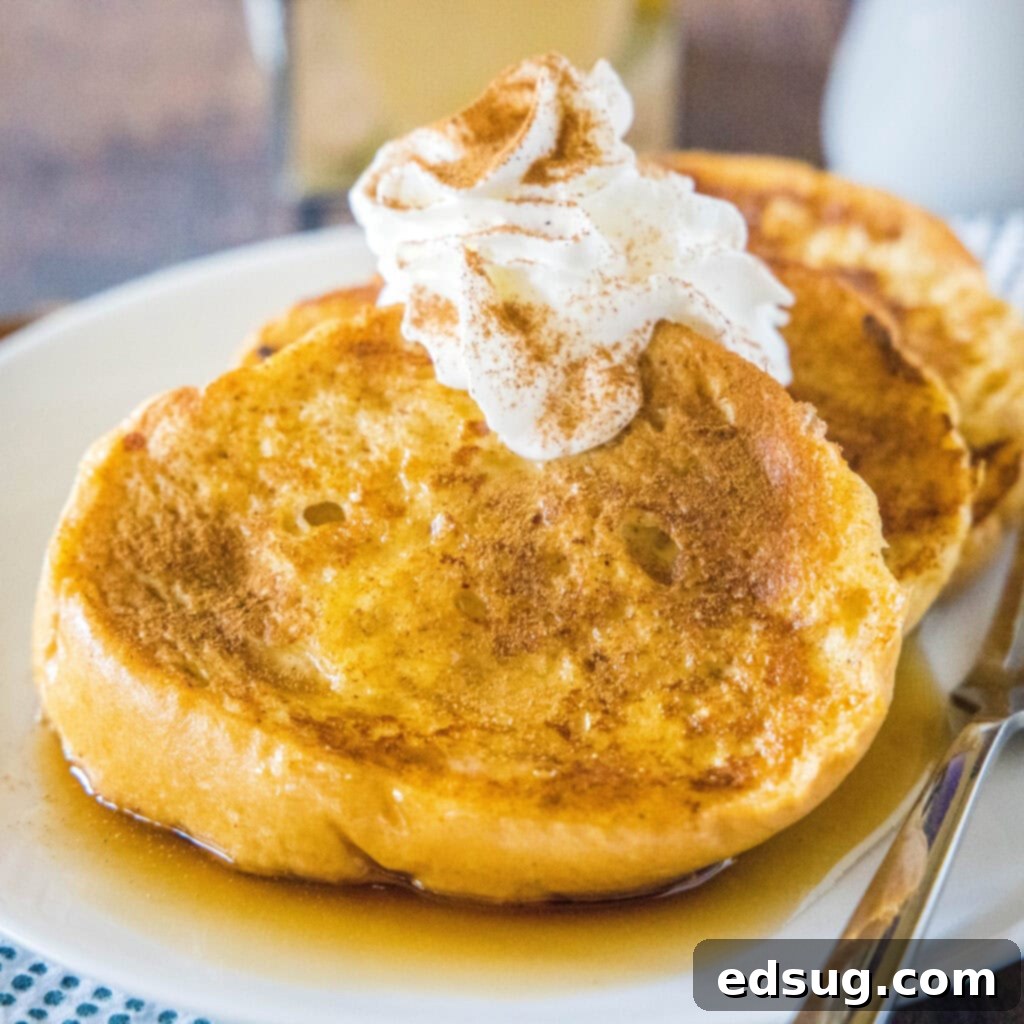 A close-up of a plate of Eggnog French Toast, garnished generously with whipped cream and a sprinkle of cinnamon, highlighting its festive appeal.