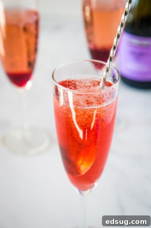 Garnet Pomegranate Sparkler 5 cocktail stir stick mixing in a glass