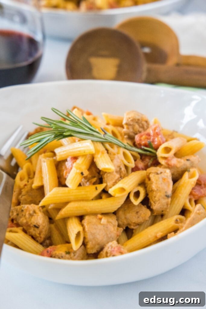 a white bowl filled with creamy sausage penne pasta
