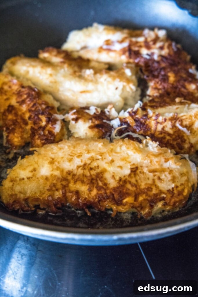 coconut chicken tenders in skillet frying