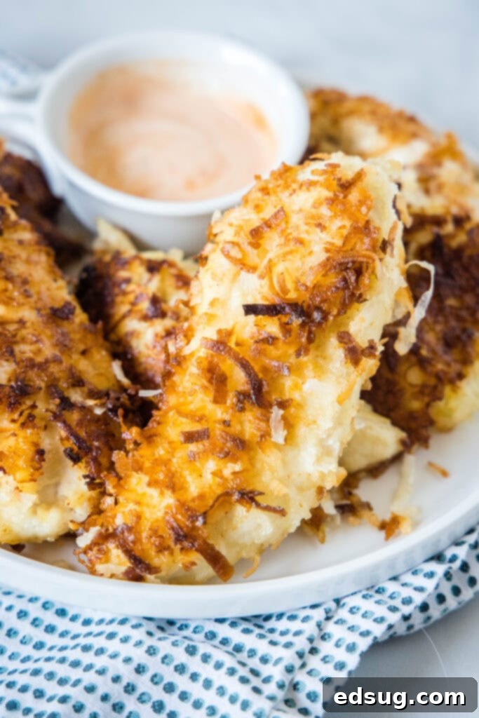 coconut chicken tenders on a white plate