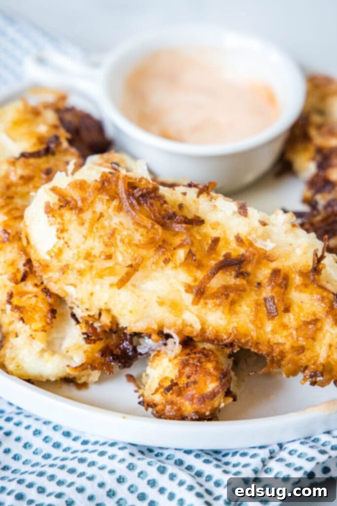 coconut chicken tenders on a white plate