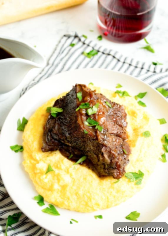 Fork-Tender Red Wine Short Ribs 5 braised beef short ribs over polenta on a plate