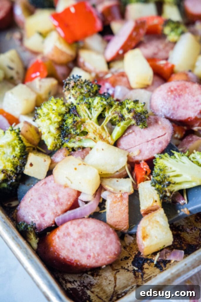 Flavorful One-Pan Sausage and Potatoes 7 A rustic cast iron skillet filled with a generous serving of cooked roasted sausage and potatoes, garnished with fresh parsley.