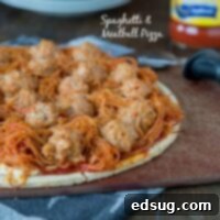 spaghetti and meatball pizza on a board